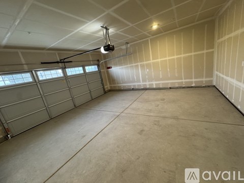 A spacious garage with a concrete floor and a hanging light fixture.