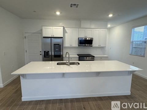A kitchen with a white countertop and stainless steel appliances.