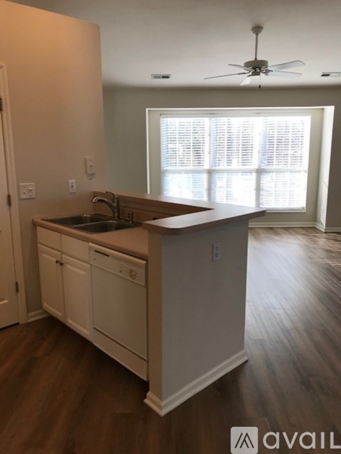 A kitchen with white cabinets and a wooden island.
