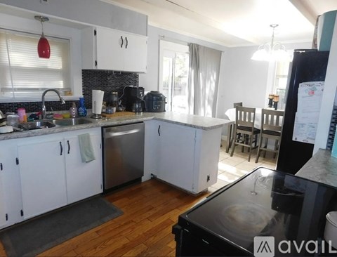 A kitchen with white cabinets and a black fridge.