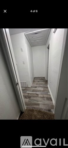 A hallway with a carpeted floor and white walls.