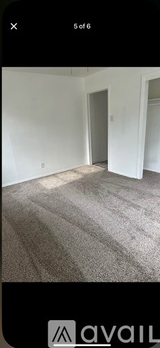 A room with a carpeted floor and white walls.