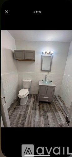 A bathroom with a toilet, sink, and mirror.