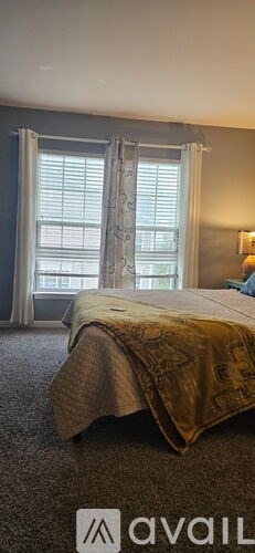 A bedroom with a bed and a window with curtains.