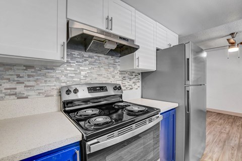 A modern kitchen with a stove top oven and a refrigerator.