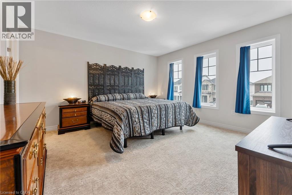 A bedroom with a large bed and a window with blue curtains.
