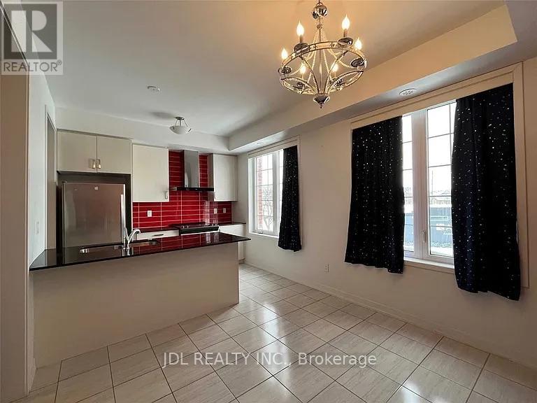 A spacious kitchen with a chandelier and a dining area with a table and chairs.