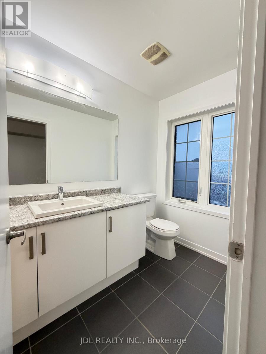 A bathroom with a toilet, sink, and mirror.