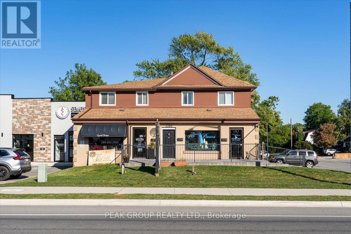 A real estate office with a sign that says "Peak Group Realty LTD, Brokerage".