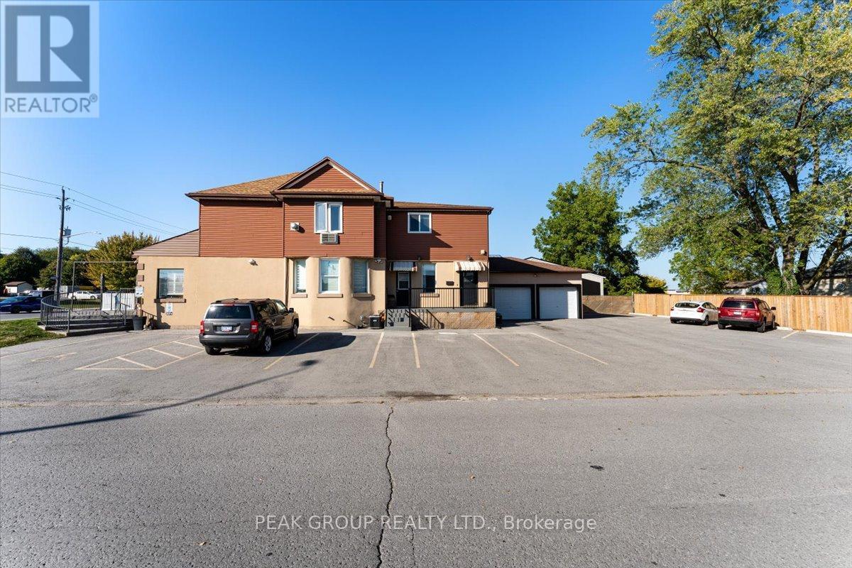 A parking lot in front of a brick building with a sign that says Peak Group Realty LTD.