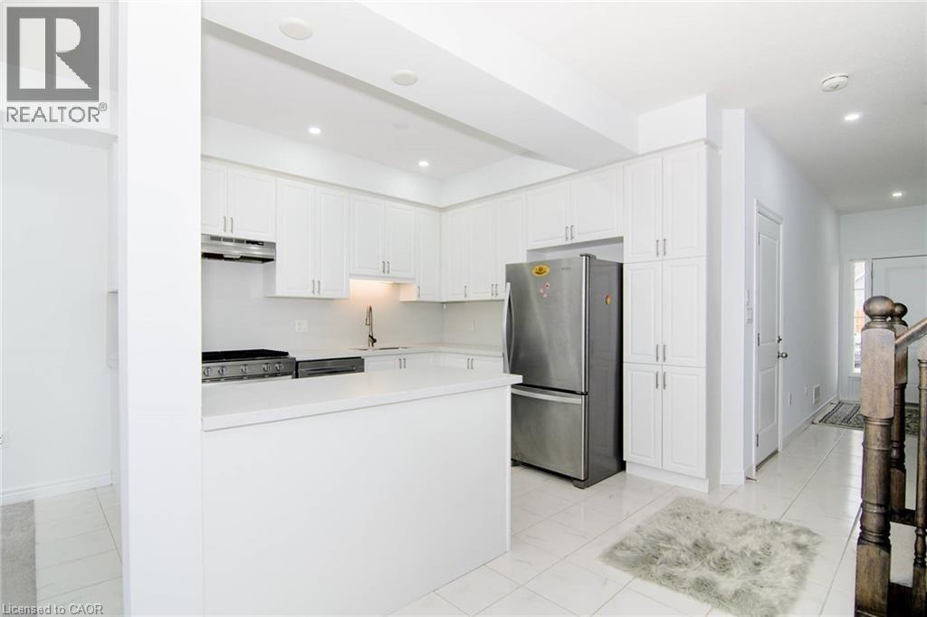 A modern kitchen with white cabinets and stainless steel appliances.