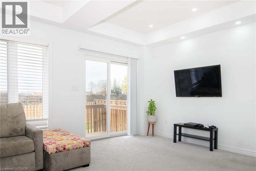 A living room with a couch, a chair, a small table, and a television mounted on the wall.