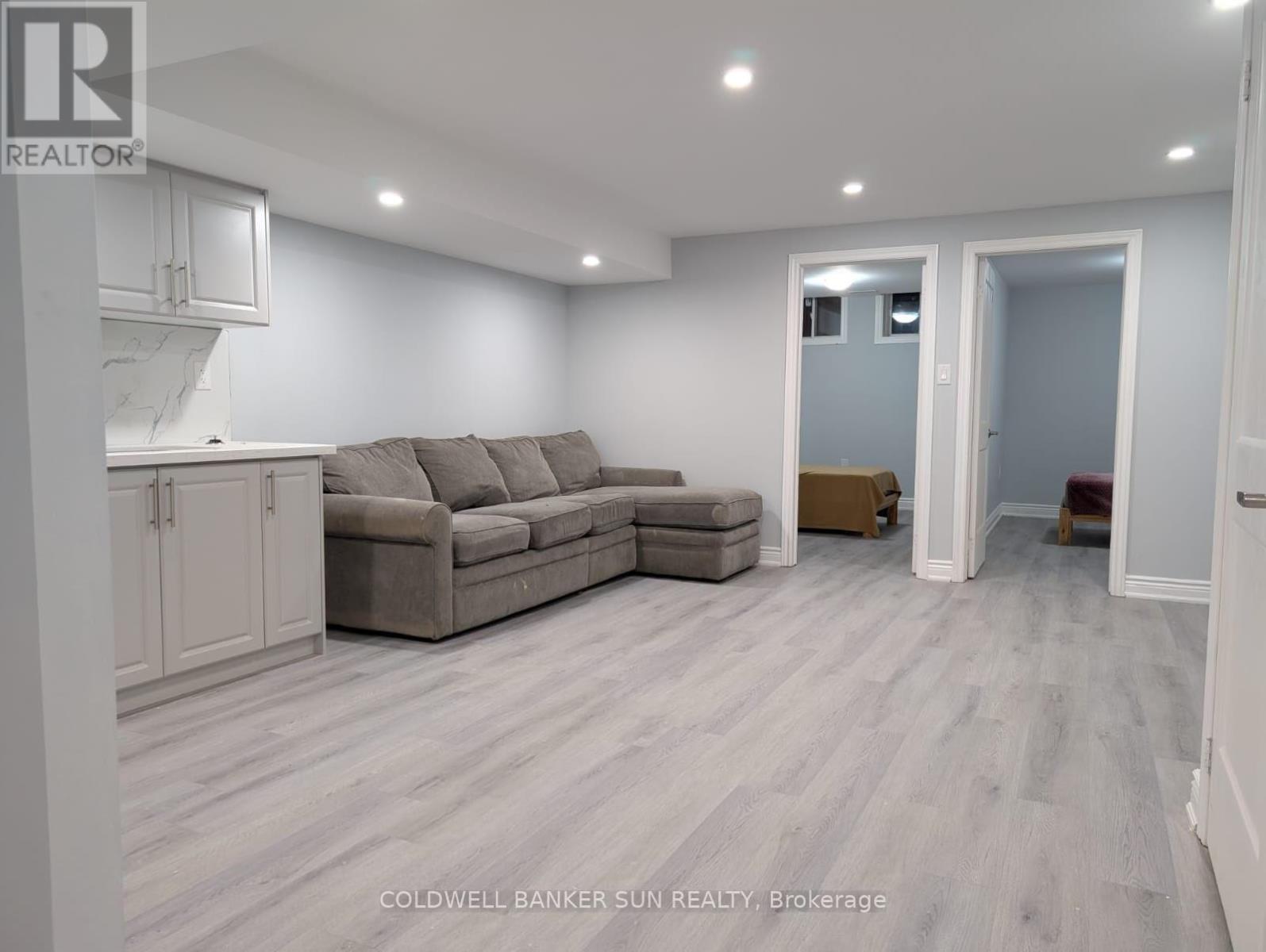 A living room with a grey couch and a white cabinet.