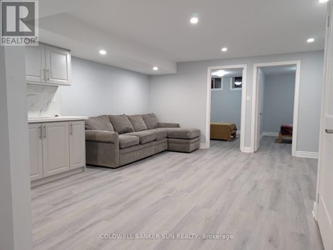 A living room with a grey couch and a white cabinet.