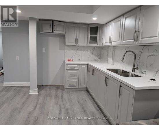 A kitchen with white cabinets and a marble countertop.