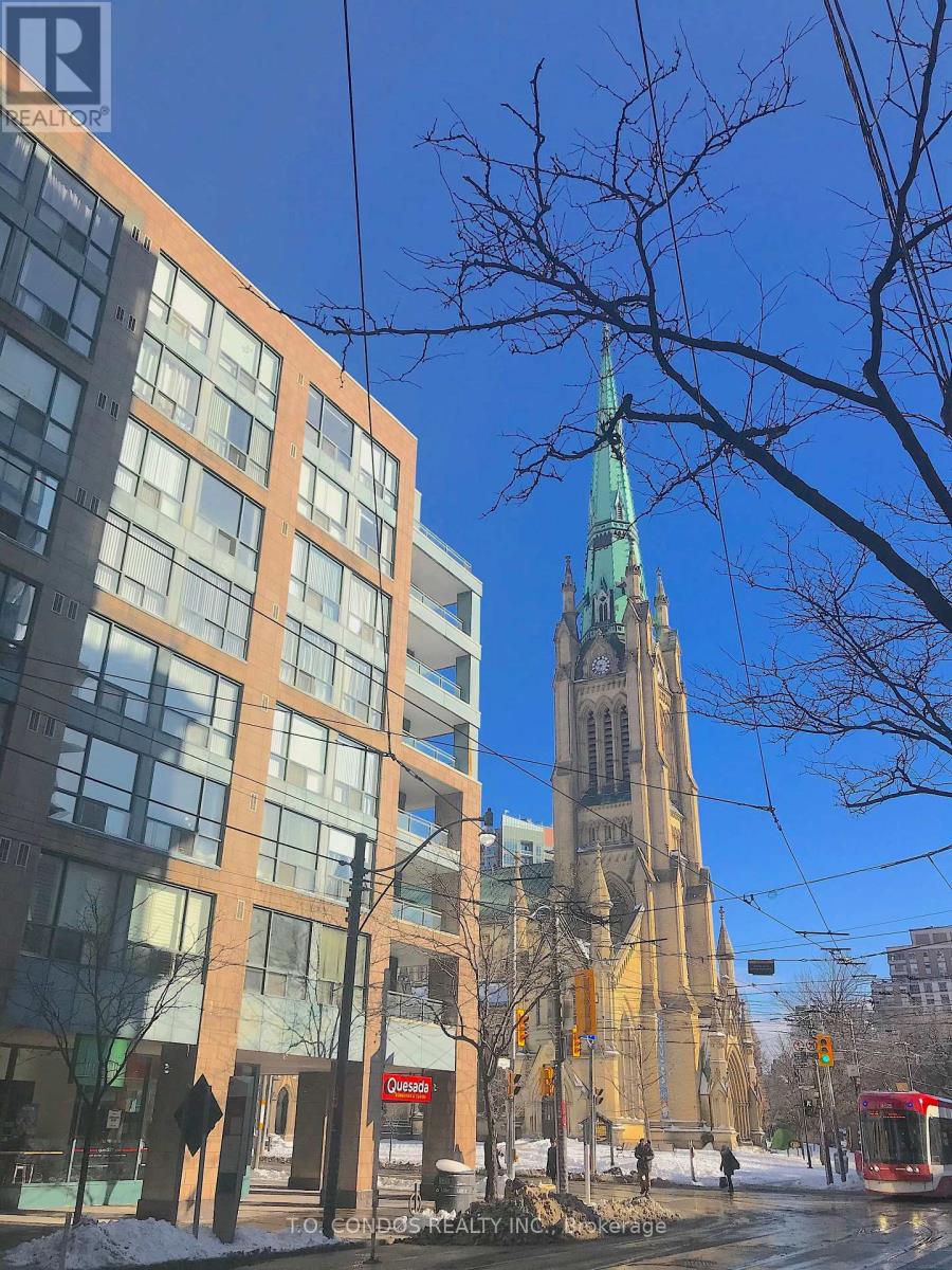 A tall building with a green spire stands behind a modern building with a red sign that says "Castro".