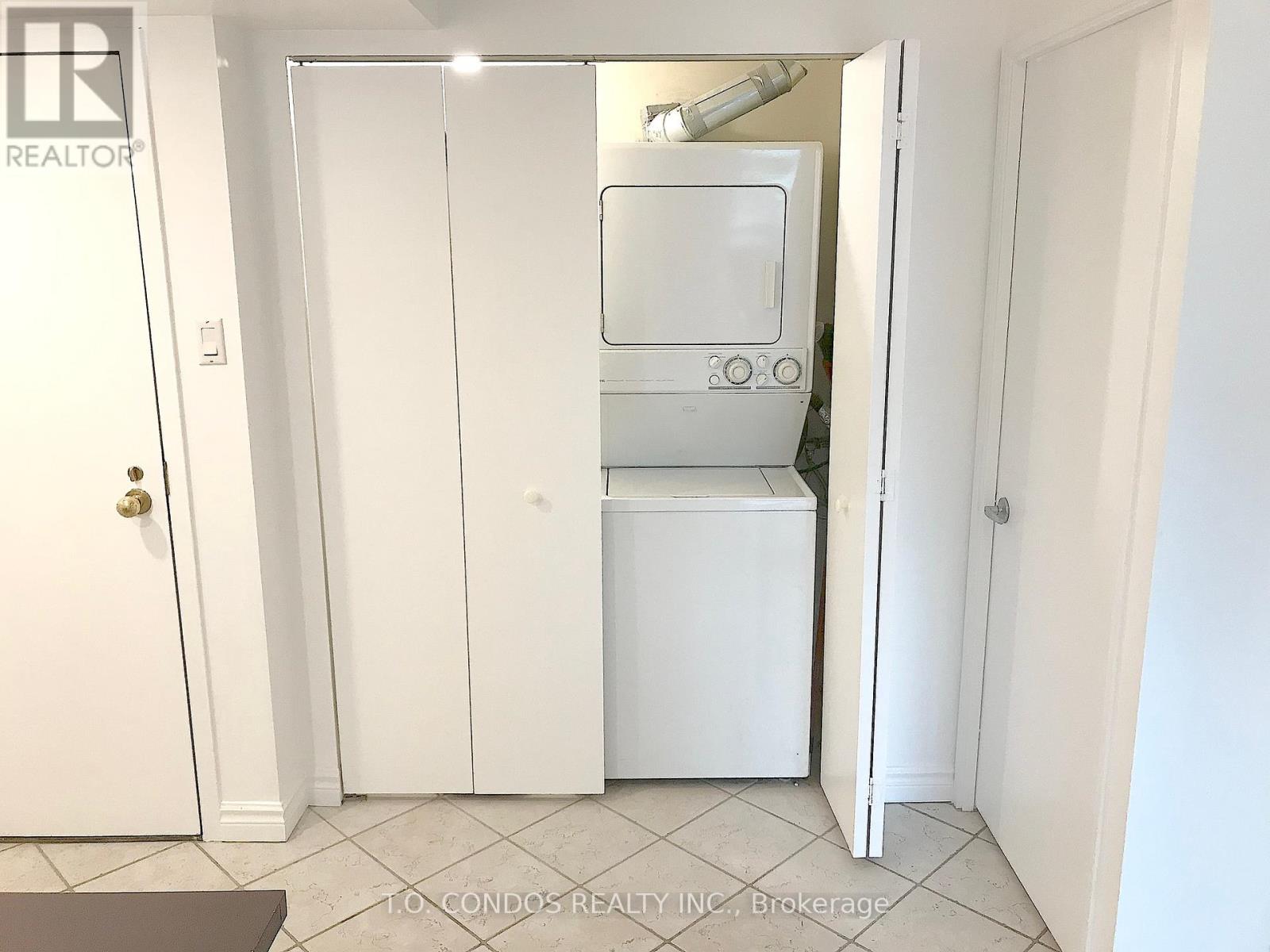 A white refrigerator is in a small kitchen.