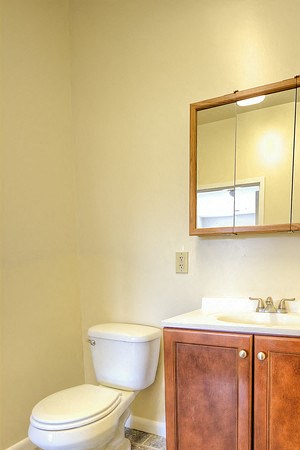 Bathroom with wooden cabinets and white sink - Photo Gallery 3