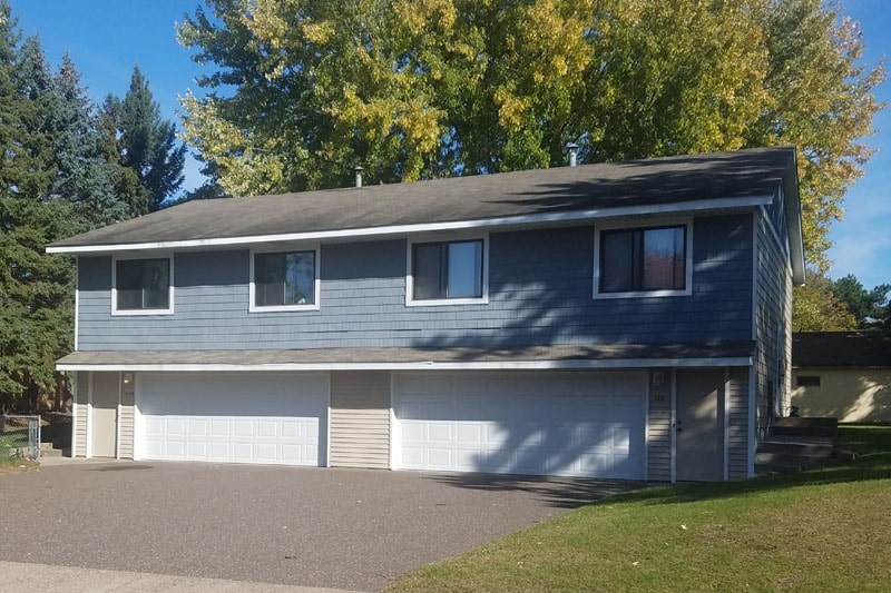 A grey house with a white garage door.