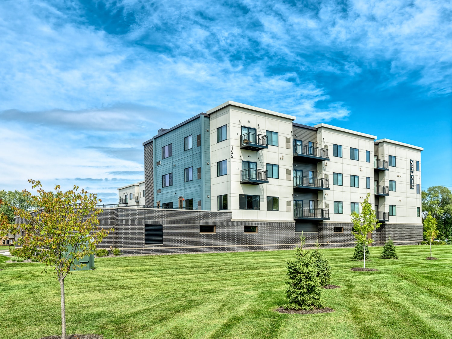 A large apartment building with a grassy area in front.