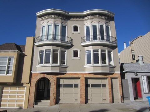 A two-story house with a balcony on the second floor.