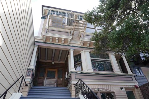 A house with a balcony and stairs leading to the front door.