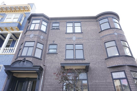 A brown building with a tree in front of it.