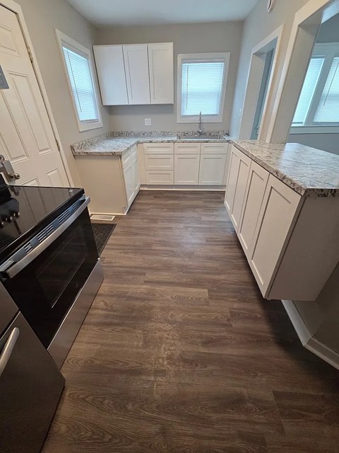 A kitchen with a black stove top oven and white cabinets.