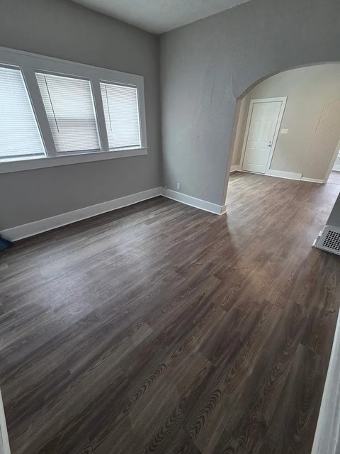 A room with wooden flooring and a window.