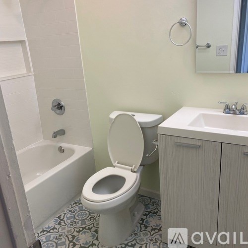 A white toilet with a white sink and a white bathtub in a bathroom.