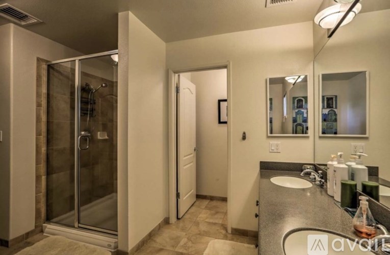 A bathroom with a sink, mirror, and shower.