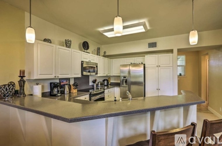 A kitchen with a granite countertop and stainless steel appliances.