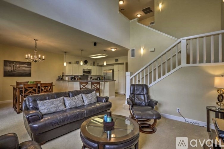 A living room with a couch, chairs, and a coffee table.