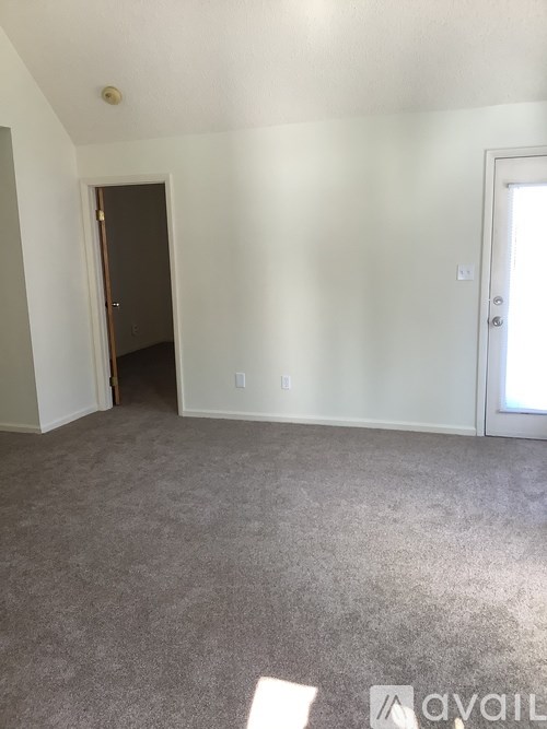 A room with a carpeted floor and a door in the back.