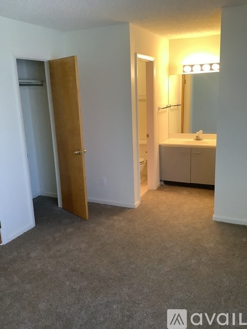 A bathroom with a sink, mirror, and a door open to a hallway.