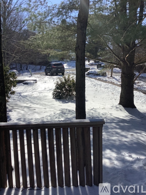 A snowy landscape with a wooden fence in the foreground.