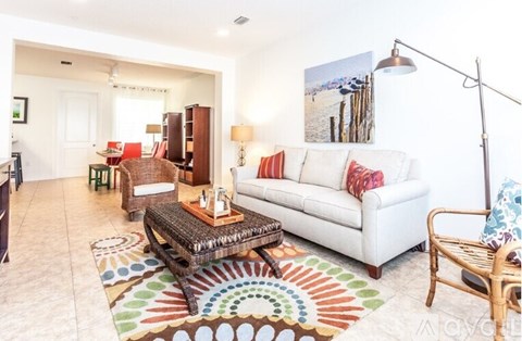 A living room with a white couch and a wooden coffee table.