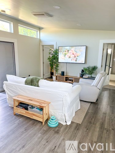 A living room with a white couch and a wooden coffee table.