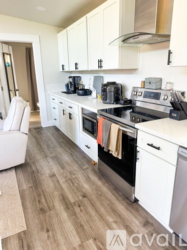 A kitchen with white cabinets and a wooden floor.