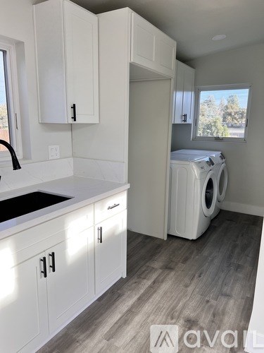 A white kitchen with a washer and dryer in it.