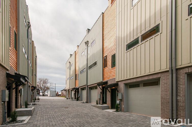 A long, narrow alleyway between two buildings with garage doors.