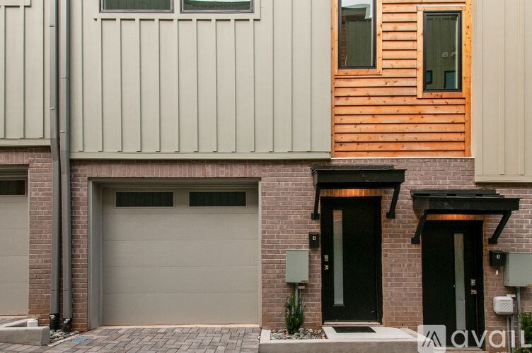 A modern house with a black door and a wooden window.