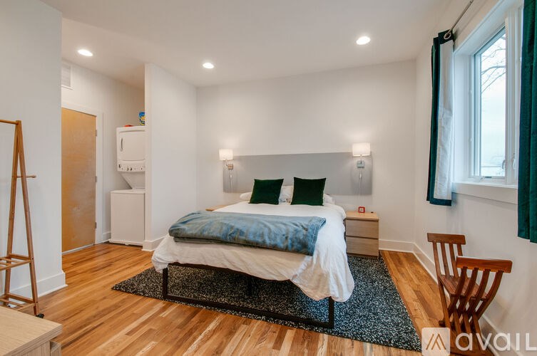 A bedroom with a bed, nightstand, and chair.