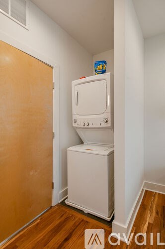 A white fridge in a room with a brown door.