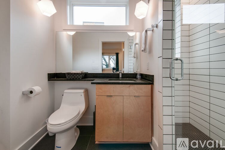A bathroom with a toilet, sink, and mirror.