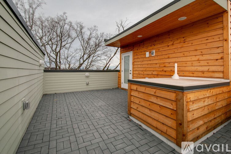 A wooden deck with a hot tub on a patio.