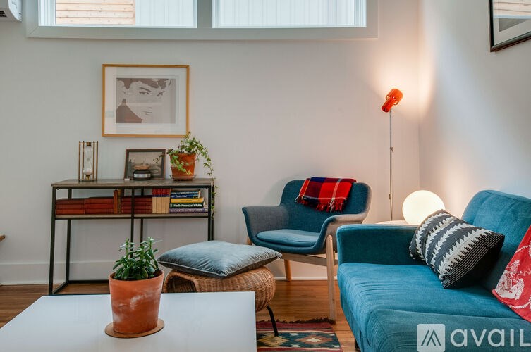 A living room with a blue couch, a coffee table, and a chair.