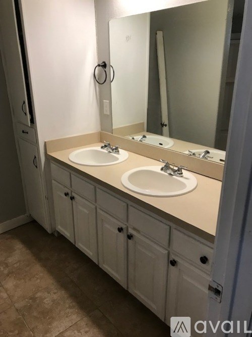 A bathroom with two sinks and a large mirror.