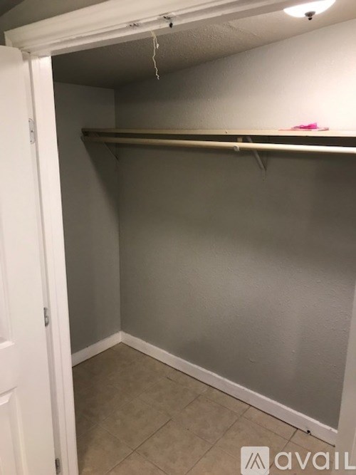 A small, empty closet with a white door and a shelf.