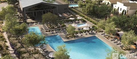 An outdoor swimming pool surrounded by trees and lounge chairs.